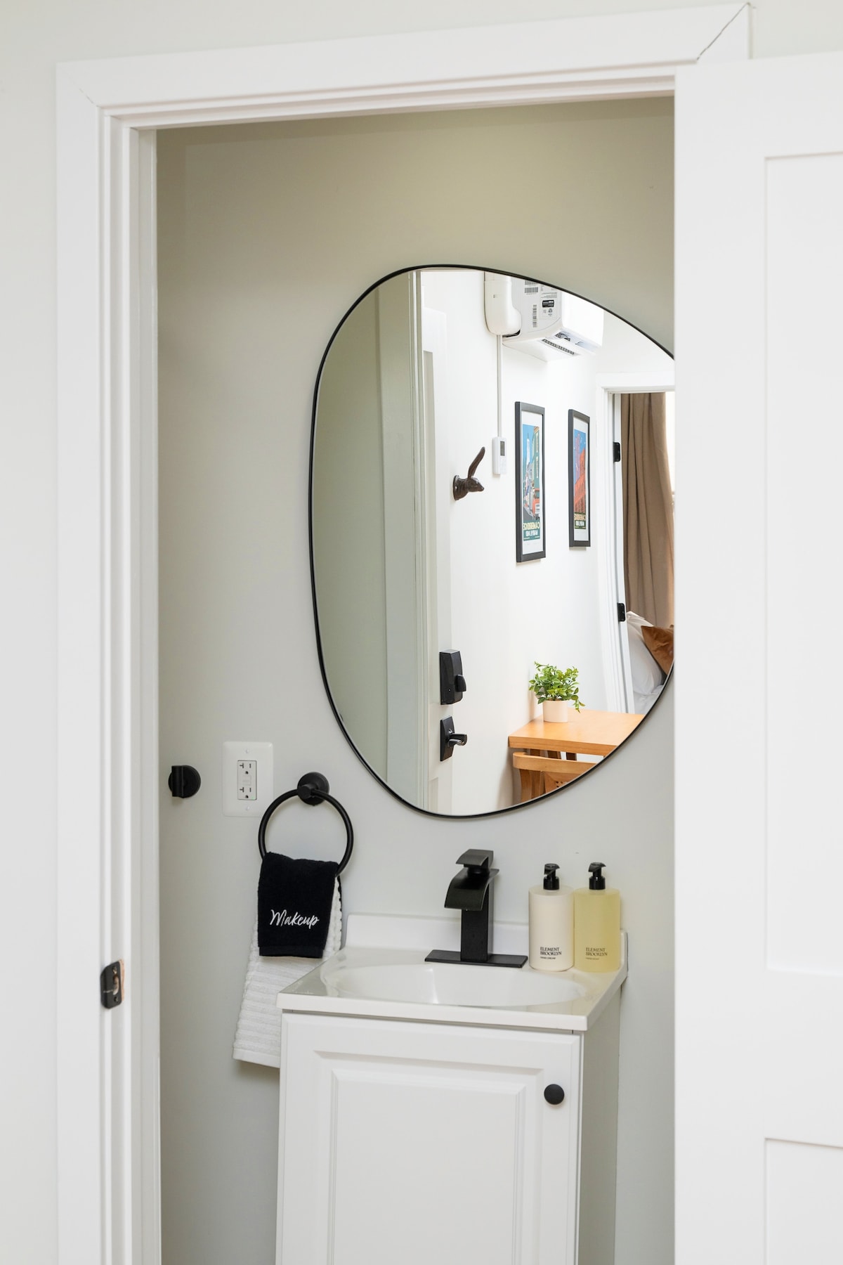 Bathroom with oval mirror and modern vanity