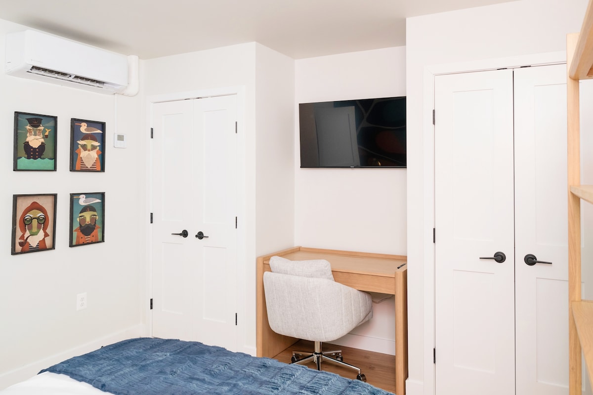 Workspace with smart TV, desk, and quirky art